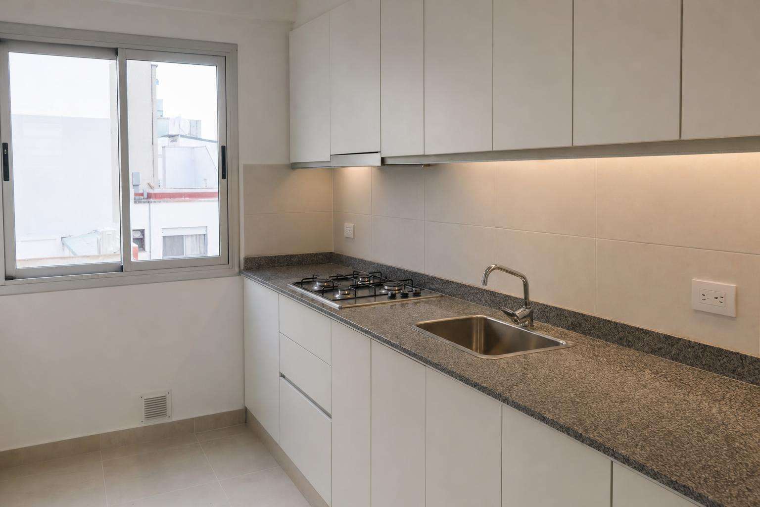 Cocina recién terminada con mesada de granito y anafe a gas: remodelación de cocina en Mar del Plata